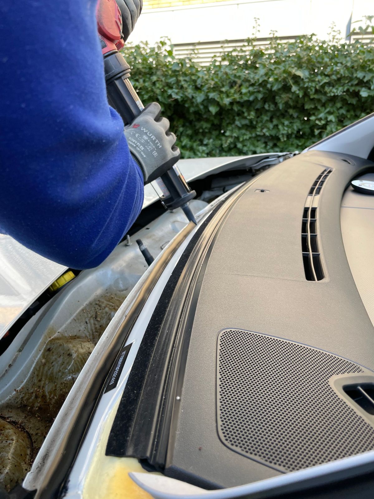 Technician preparing a windshield opening with adhesive